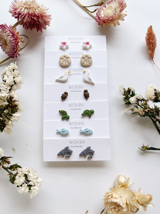 Set of earrings on a display card with dried flowers around