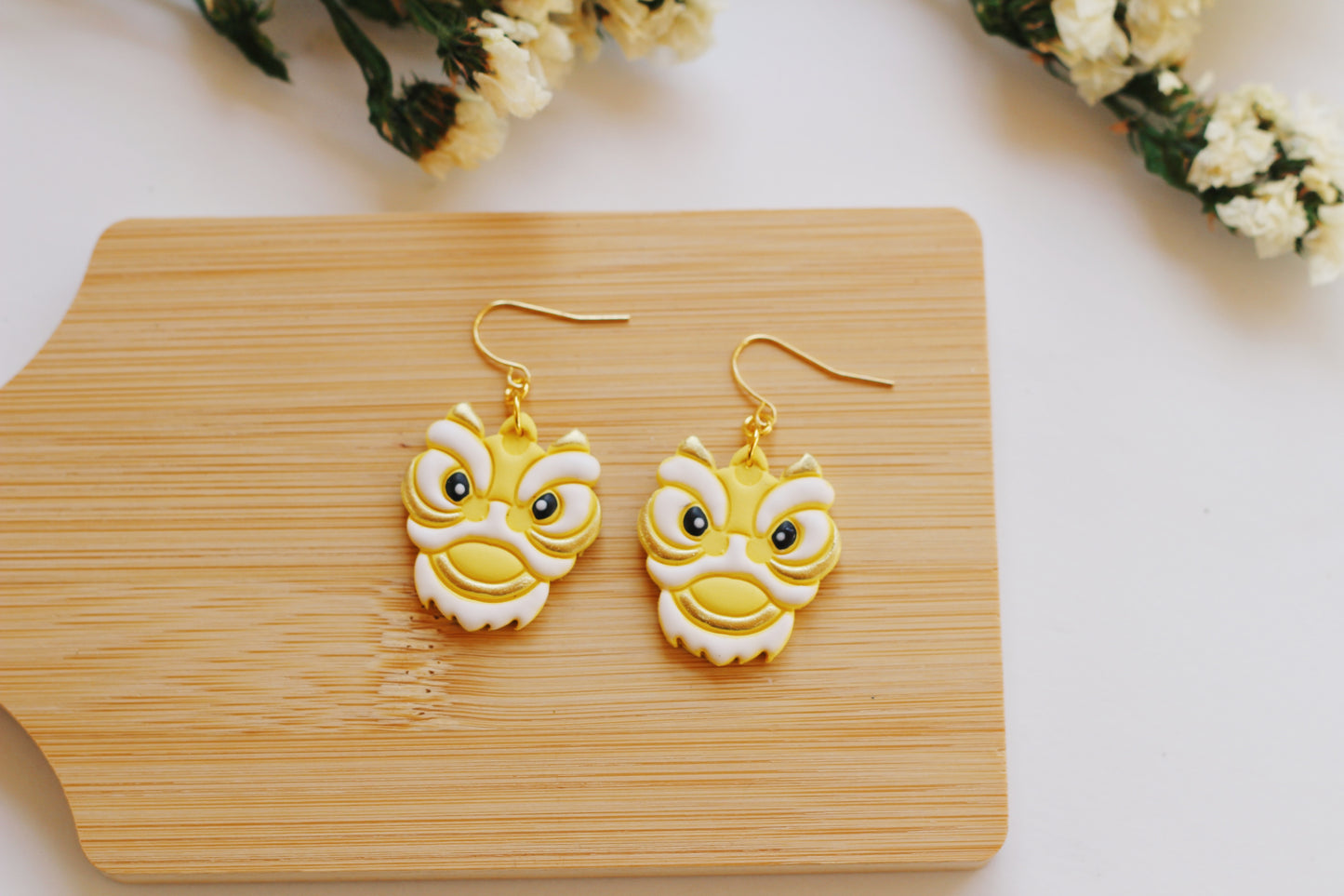 Yellow and white Chinese lion head earrings with gold hooks