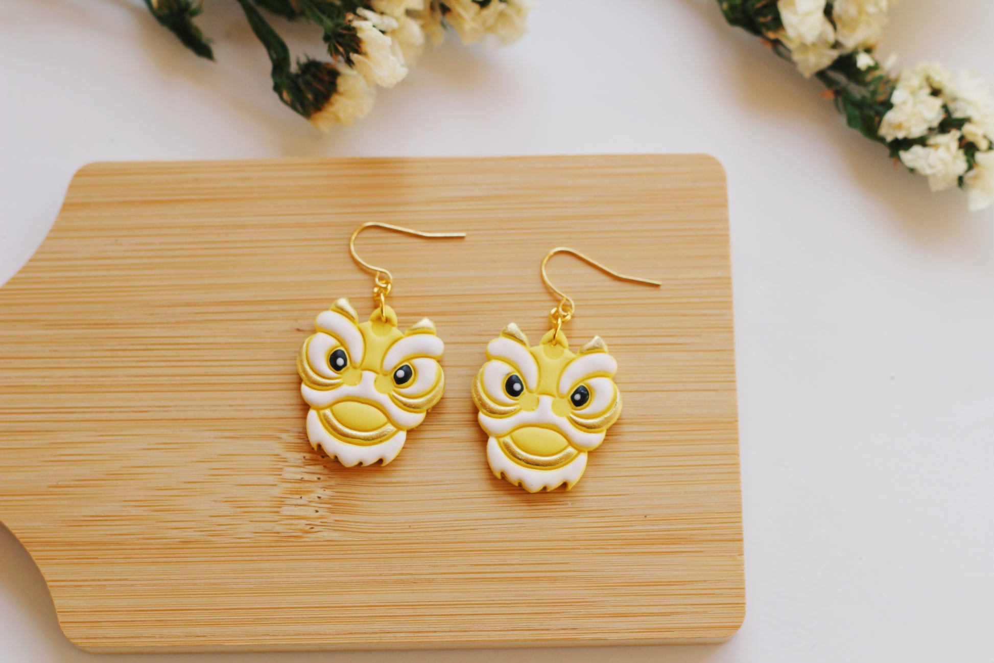 Yellow and white Chinese lion head earrings with gold hooks