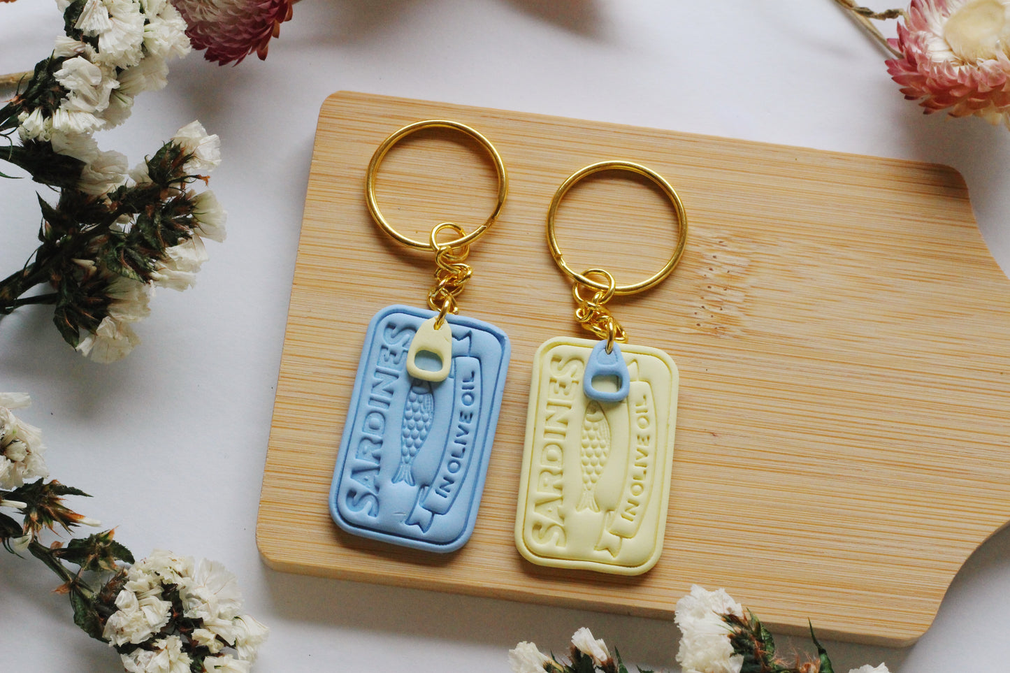 Two keychains on a wooden board with floral decorations