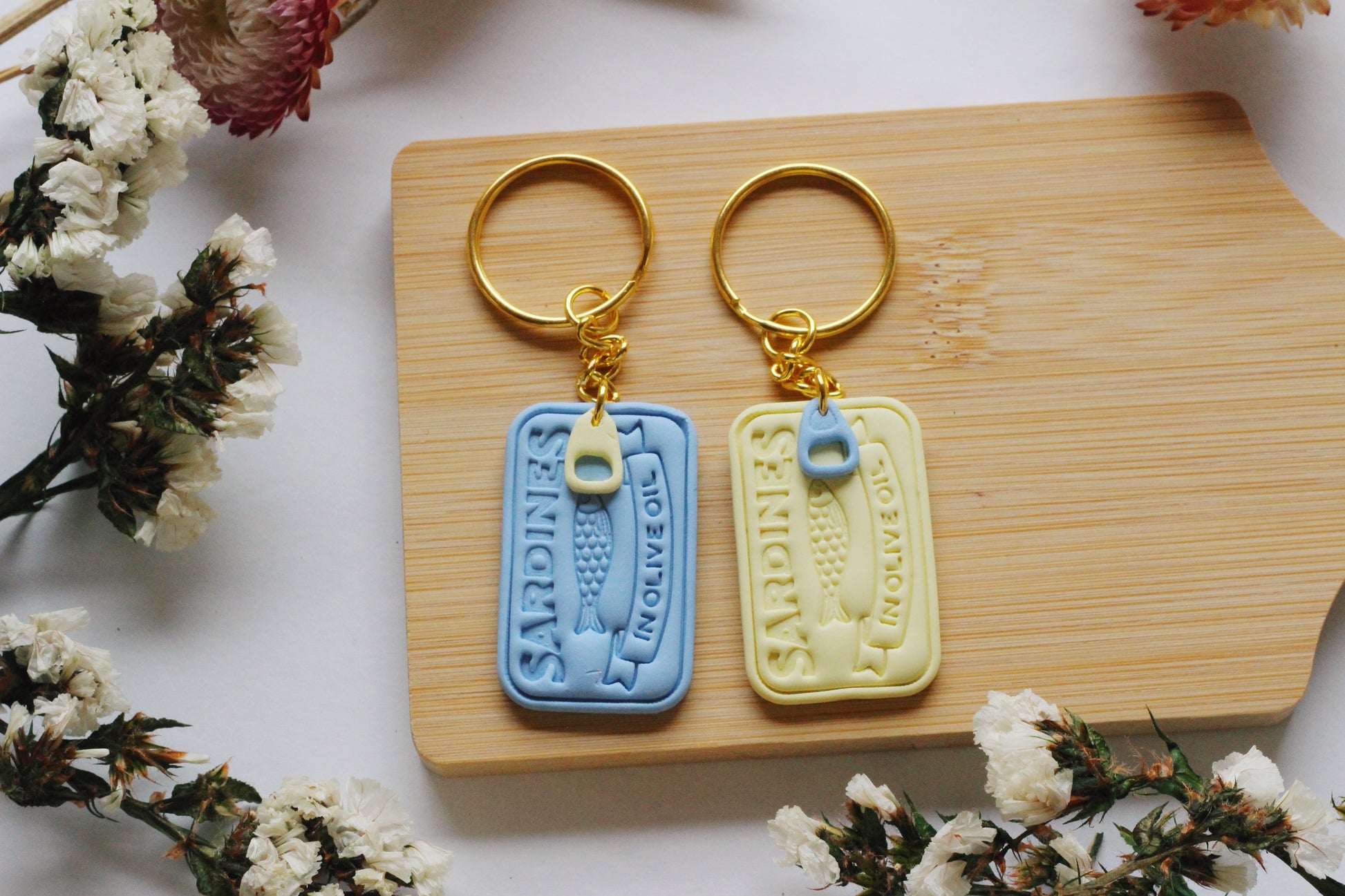 Two keychains on a wooden board with floral decorations