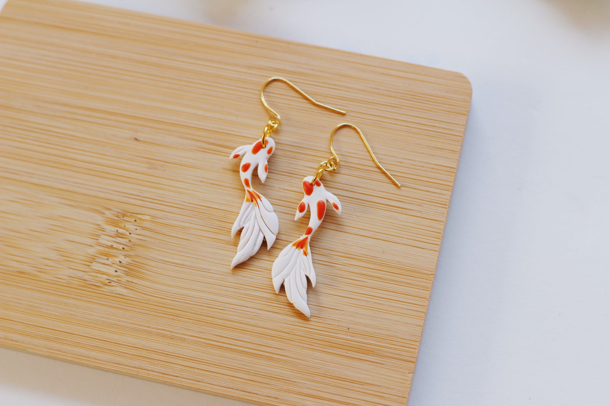 White and orange koi fish earrings with gold hooks