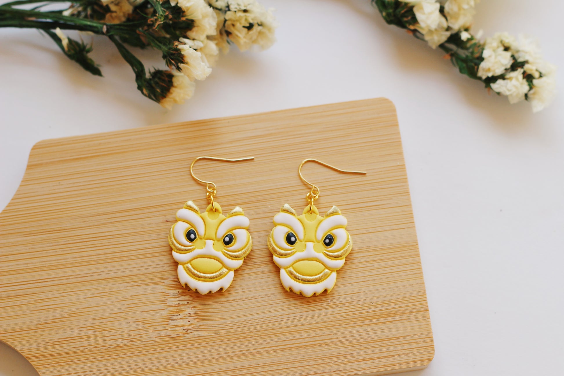Yellow and white Chinese lion head earrings with gold hooks