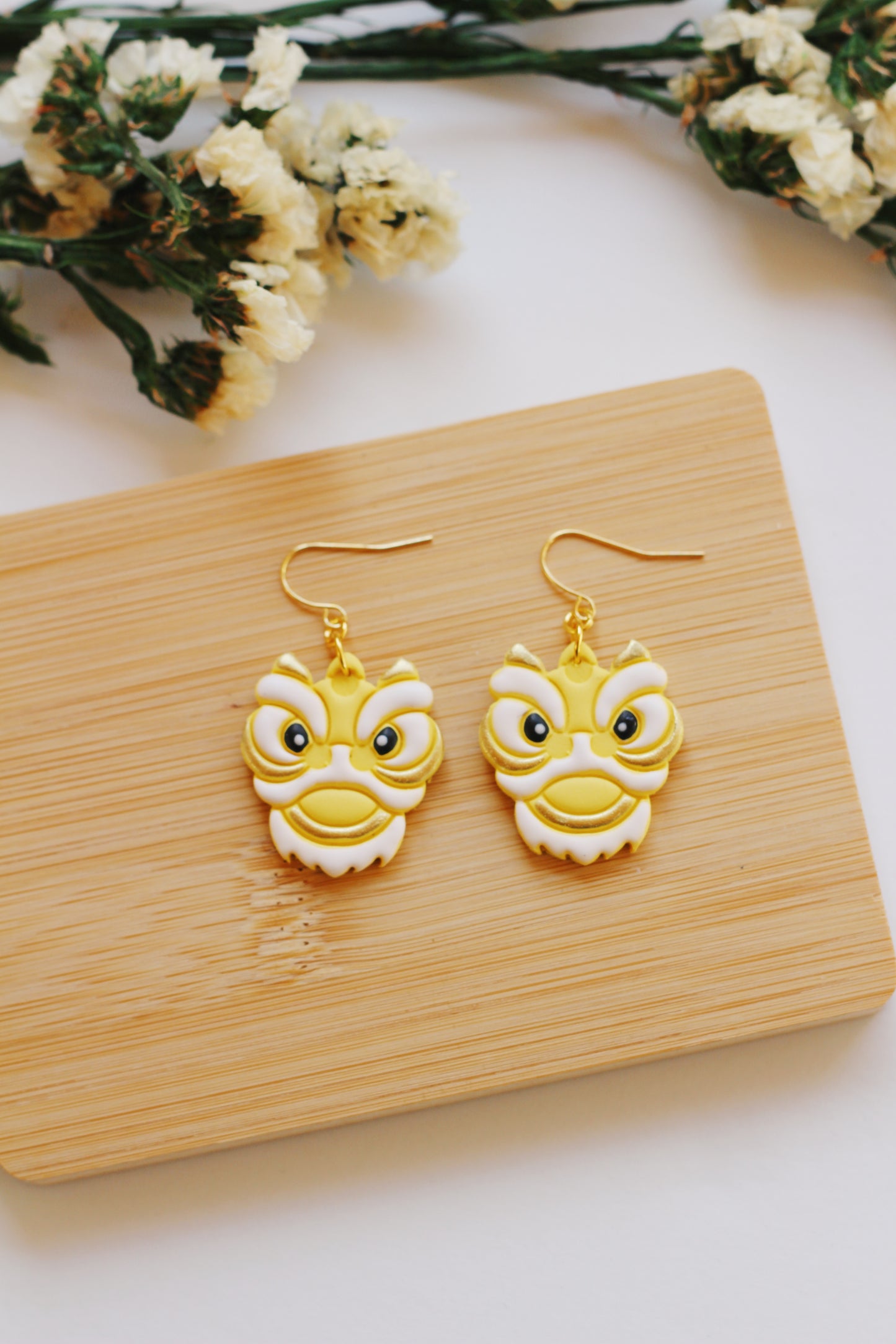 Yellow and white Chinese lion earrings with gold hooks