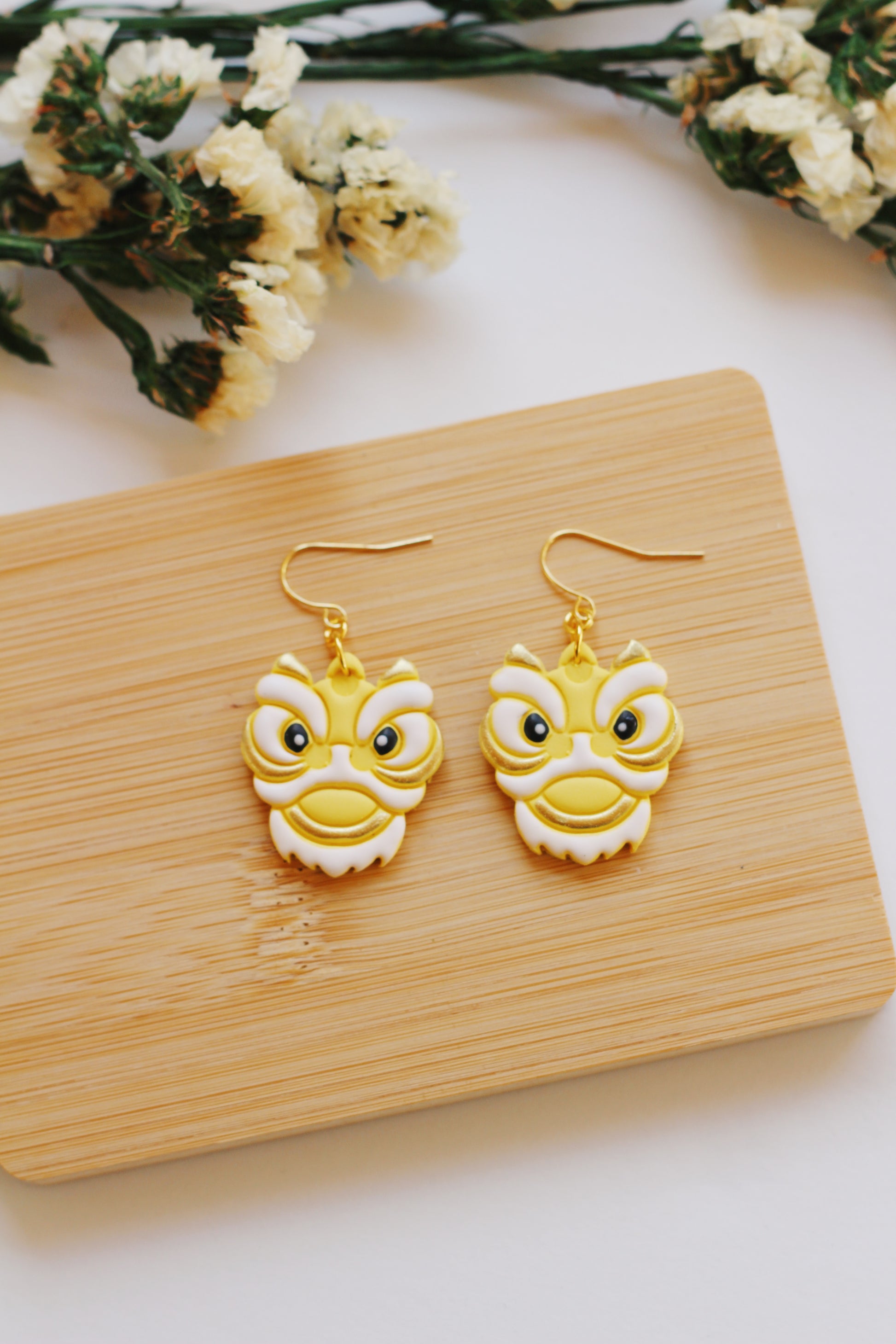 Yellow and white Chinese lion earrings with gold hooks