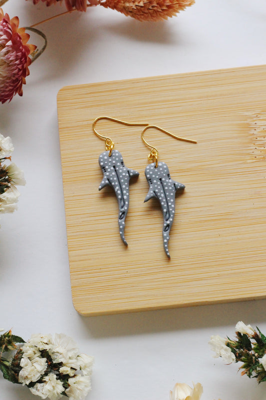 Whale shark earrings on a wooden board